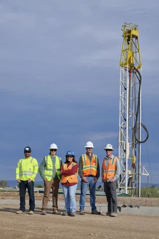 Industrial team photography of oil and gas workers in safety gear at drilling rig site in Arizona