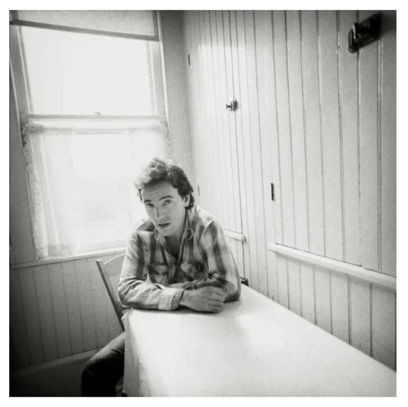 Young Bruce Springsteen sitting at a kitchen table, black and white portrait by David Michael Kennedy