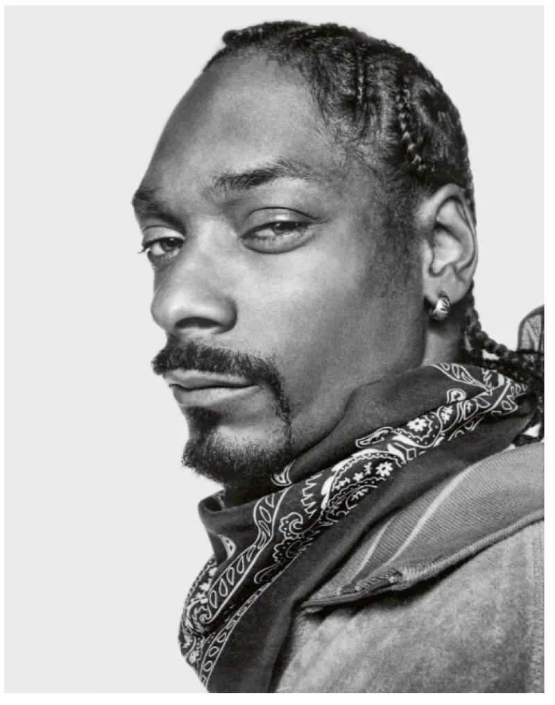 Close-up black and white portrait of Snoop Dogg with braids and bandana, photograph by Donald Graham