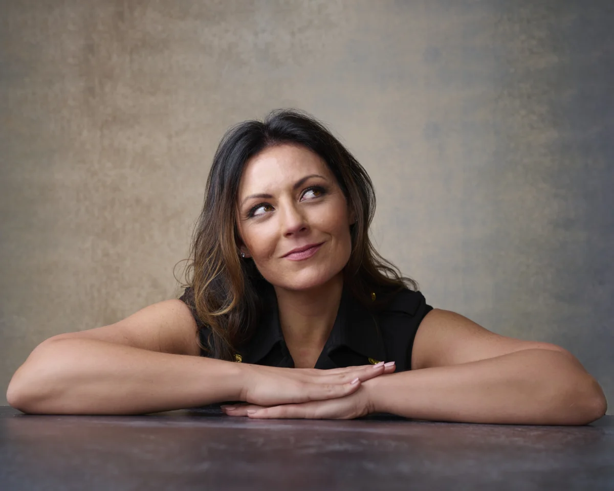 Relaxed personal branding portrait of Natalie leaning on a table in a Gilbert studio Phoenix Arizona