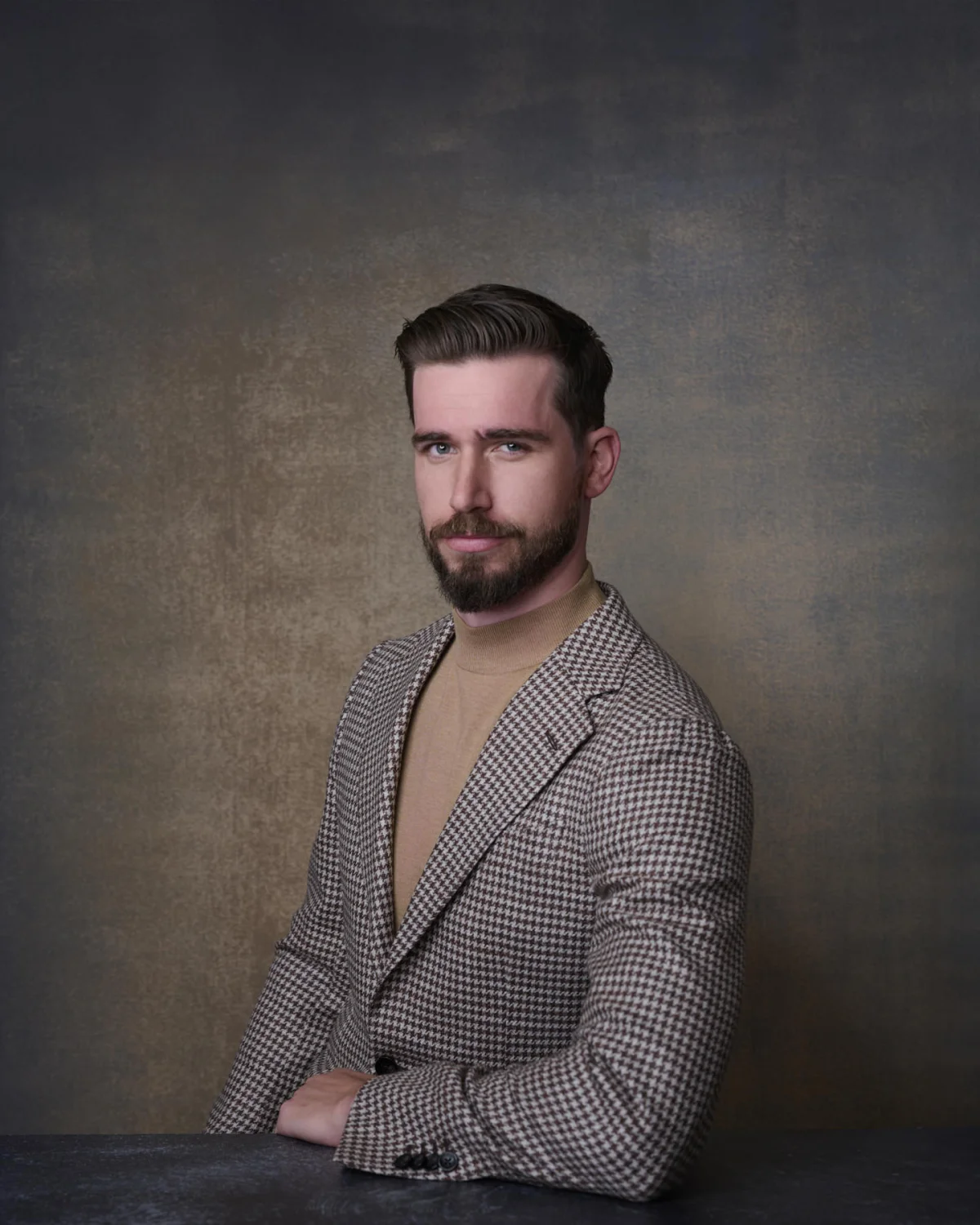 Tommy in a houndstooth blazer against a hand-painted backdrop, personal branding portrait in a Gilbert Arizona studio