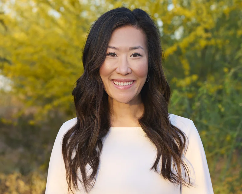Outdoor corporate headshot of Janelle dentist with Arizona greenery background Phoenix
