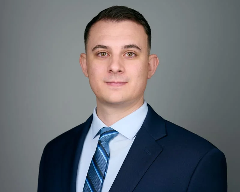Male medical student in navy suit with striped tie polished ERAS headshot for residency application Phoenix Arizona