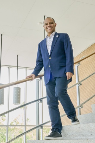Stefano McGhee, full-length portrait on an interior staircase